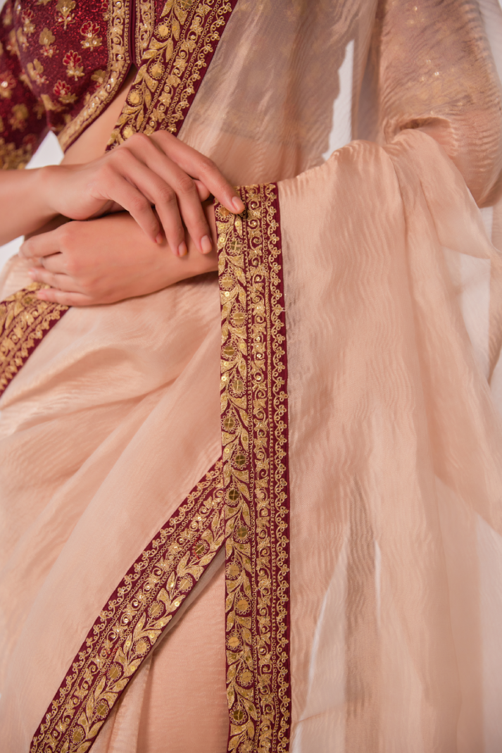 Gold hued peach crush tissue embroidered Saree with elbow sleeve blouse
